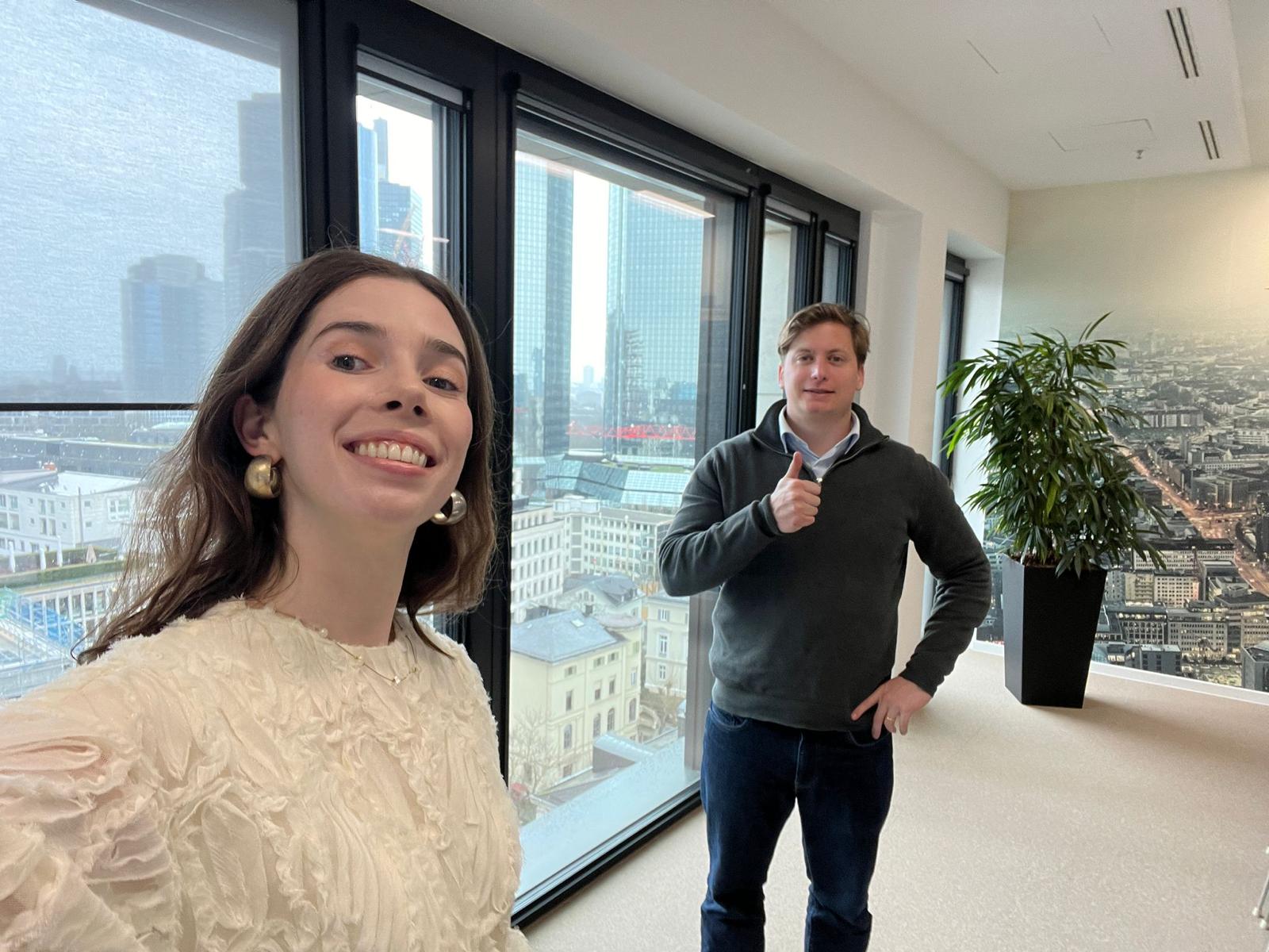 Two WAIMAKERS colleagues at the office with a city skyline behind them